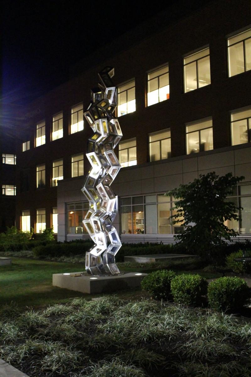 The Synergy sculpture outside the Proteomics Building at night
